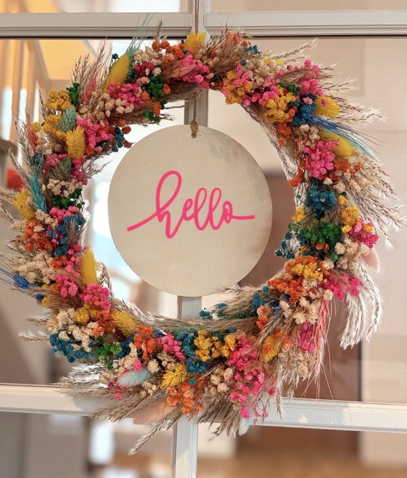 Bunter Kranz aus Trockenblumen mit einem runden Schild und dem Schriftzug hello.