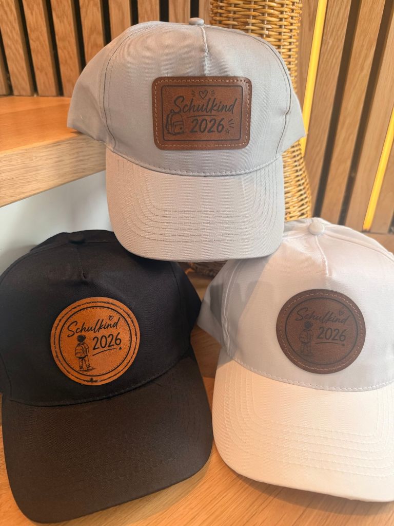 Drei Basecaps mit aufgesetzten Patches aus Kunstleder, hell und dunkel.